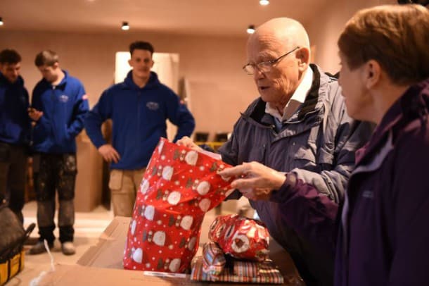 David Haylock (second right) and his wife Carol look at presents given to them by builders Miles Shaw, Scott Elvin, Lewis Shaw and Richard Shaw (not pictured) who found a 60-year-old note he wrote to Father Christmas stuck in the chimney of the house he grew up in. PRESS ASSOCIATION Photo. Picture date: Friday December 11, 2015. See PA story SOCIAL Letter. Photo credit should read: Andrew Matthews/PA Wire