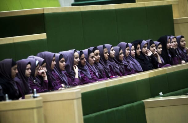 Iranian school girls observe Members of Parliament (MP) discussing a draft to limit photographer's and cameramen's access to cover parliament's open sessions in Tehran on February 27, 2013. The debate took part on the sidelines of a parliamentary session to discuss the annual budget bill which is being presented by the government. AFP PHOTO/BEHROUZ MEHRI (Photo credit should read BEHROUZ MEHRI/AFP/Getty Images)