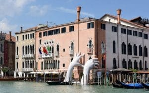mains géantes sortent d'un canal à Venise