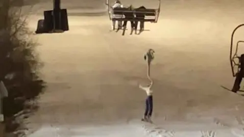 skieuse pendue dans le vide accrochée au télésiège