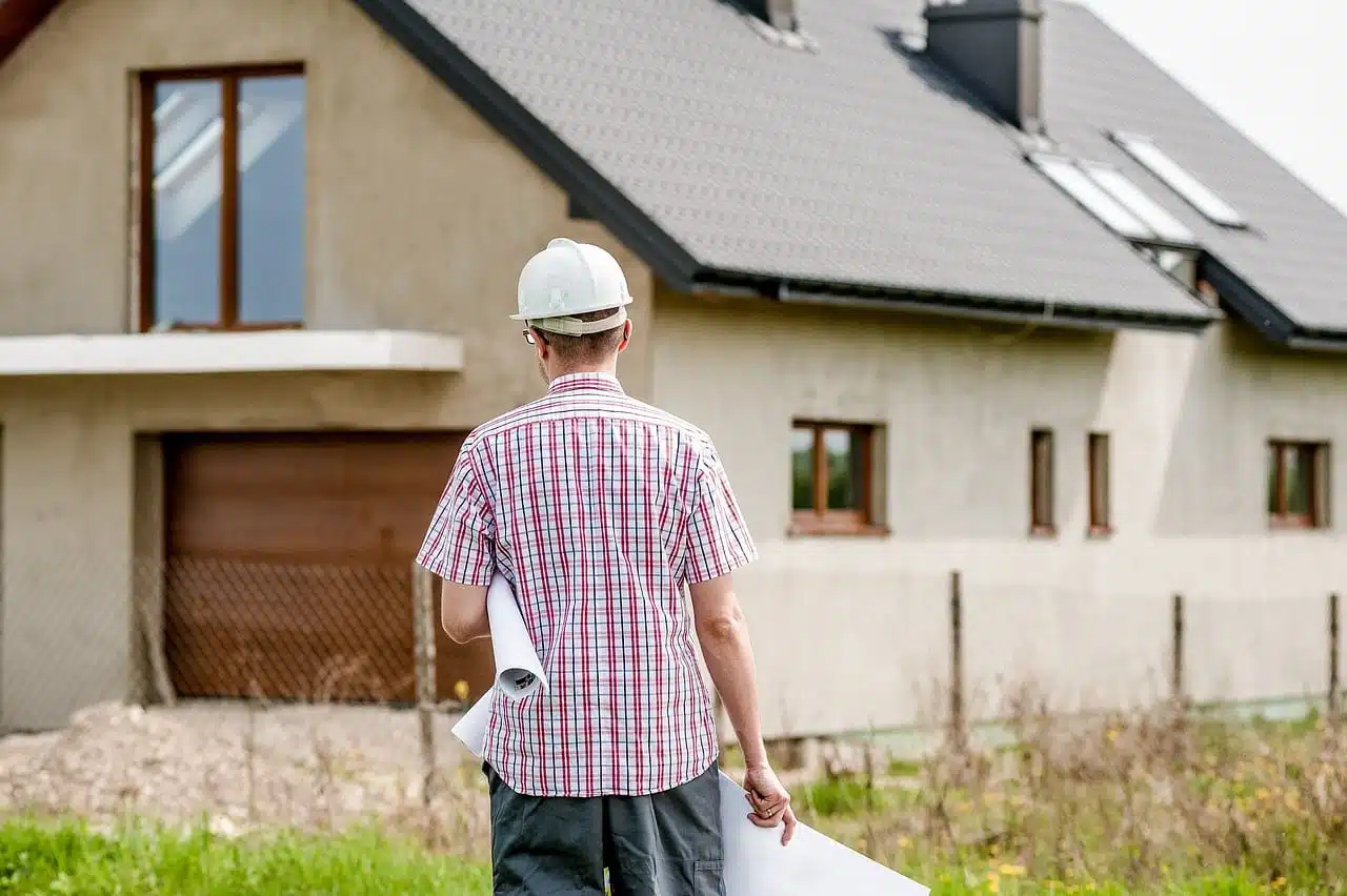 Image illustration un constructeur commence à construire une maison sur le terrain d'à côté.