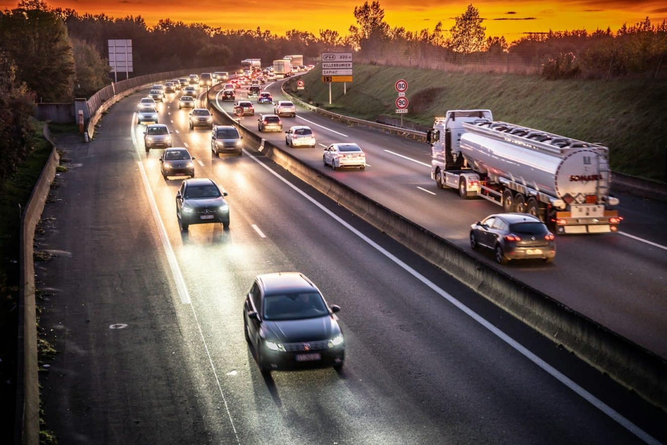 A highway filled with lots of traffic at sunset