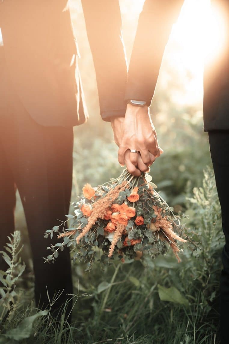 a couple of people holding a bouquet of flowers