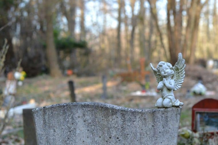 a statue of an angel sitting on top of a grave