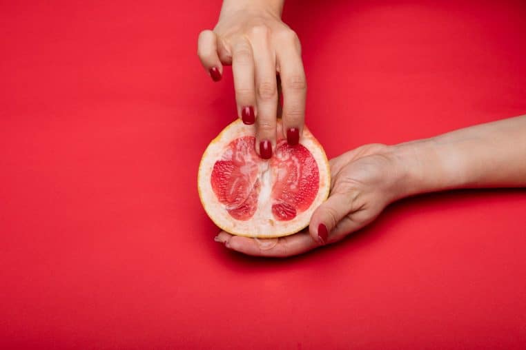 person holding sliced of orange fruit