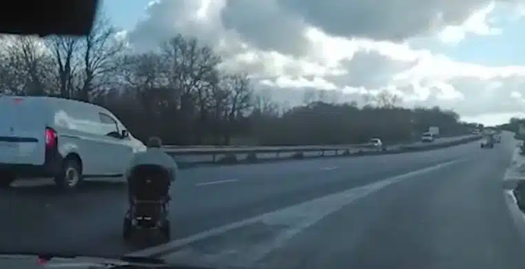 Une femme âgée sur la voie rapide avec son fauteuil